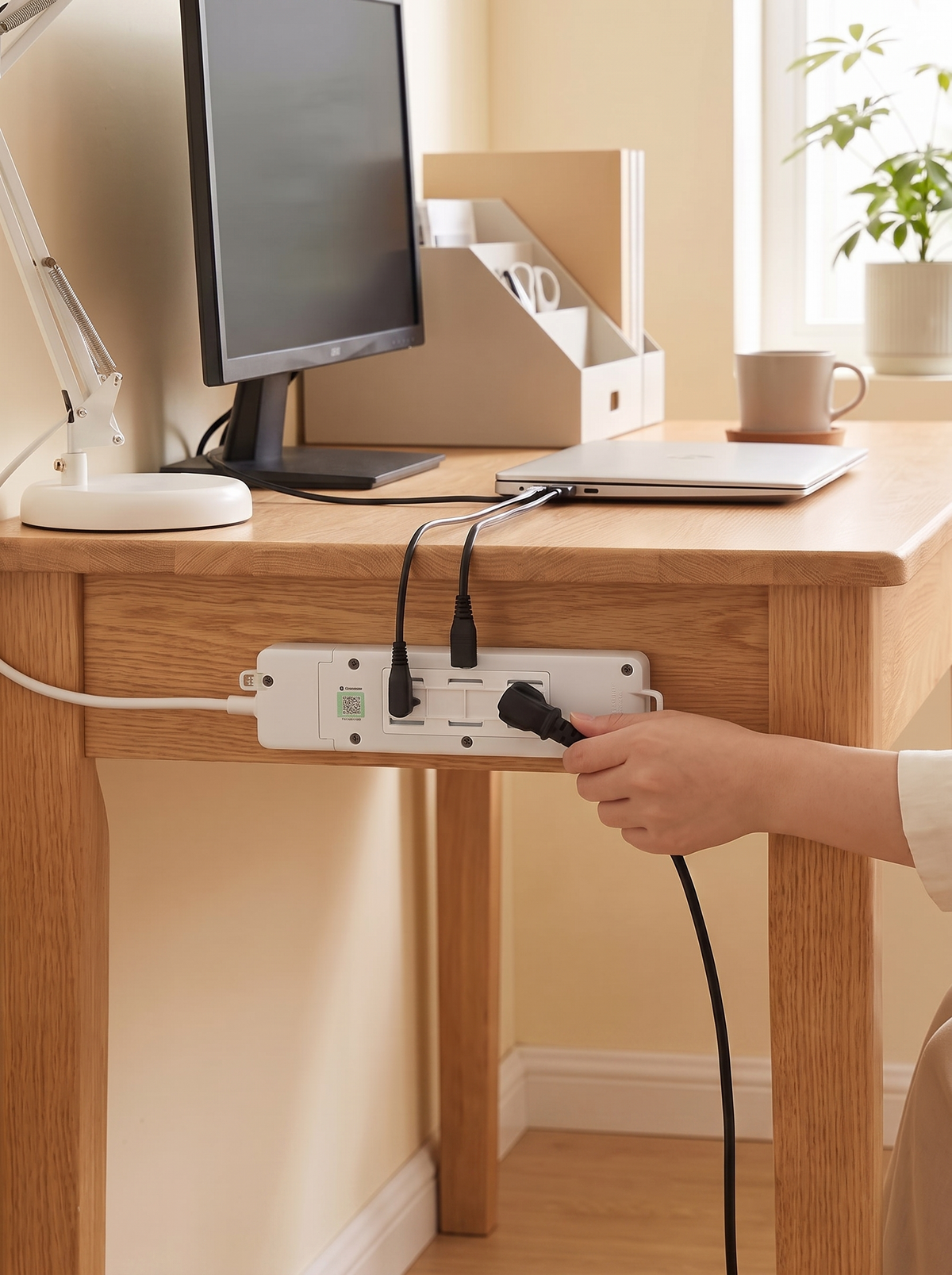 Power strip held off the floor on an adhesive holder under a desk
