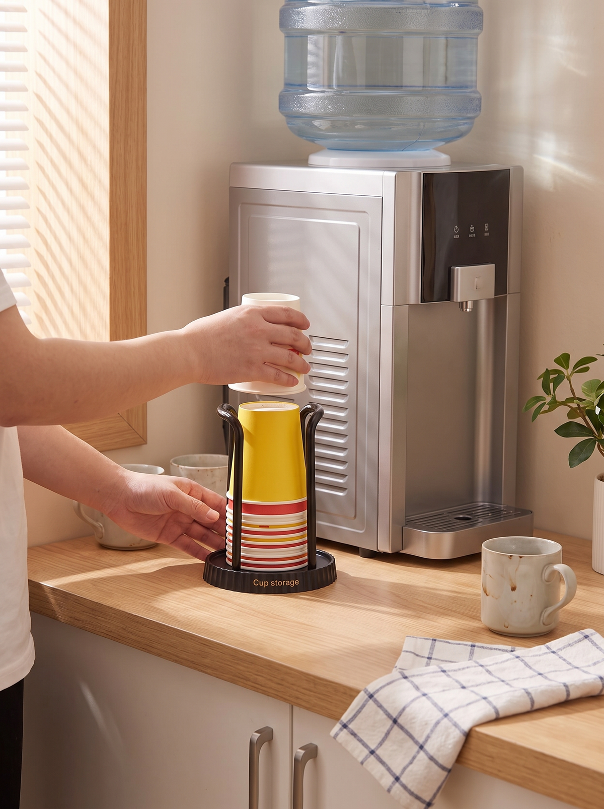 Paper cup dispenser feeding one cup at a time at a water cooler