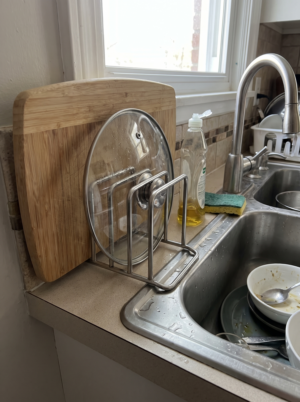 Narrow steel board holder tucked in beside a kitchen sink